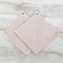 Lade das Bild in den Galerie-Viewer, Ein Paar beige gehäkelte Topflappen liegen auf einer hellen Holz-Platte