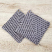 Lade das Bild in den Galerie-Viewer, Ein Paar graue gehäkelte Topflappen liegen auf einer hellen Holz-Platte