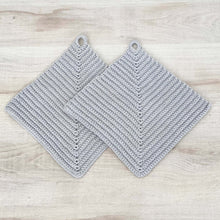 Lade das Bild in den Galerie-Viewer, Ein Paar hellgraue gehäkelte Topflappen liegen auf einer hellen Holz-Platte