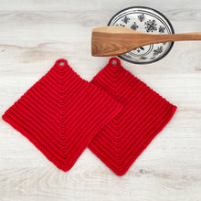 Lade das Bild in den Galerie-Viewer, Ein Paar knallrote gehäkelte Topflappen liegen auf einer hellen Holz-Platte
