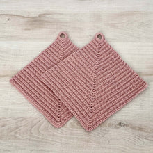 Lade das Bild in den Galerie-Viewer, Ein Paar rosafarbene gehäkelte Topflappen liegen auf einer hellen Holz-Platte