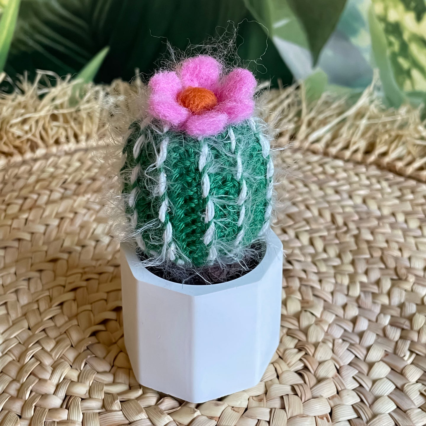 Kleiner gehäkelter Kaktus mit pinkfarbener Blüte in einem Keramiktopf