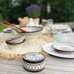 Gedeckter Holz-Tisch mit marokkanischem Geschirr aus Safi in den Farben schwarz und weiss.