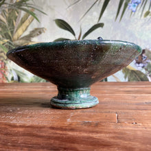 Load image into Gallery viewer, Eine marokkanische handgearbeitete grüne Keramik-Schale mit Fuß steht auf Vintage-Holztisch vor einer floralen Tapete
