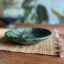 Load image into Gallery viewer, Ein grüner Keramik-Teller aus Tamgroute steht auf einem Seegras-Platzdeckchen
